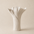 White ceramic vase with textured design on a beige background