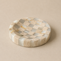 Round stone tray with a checkered pattern on a beige background